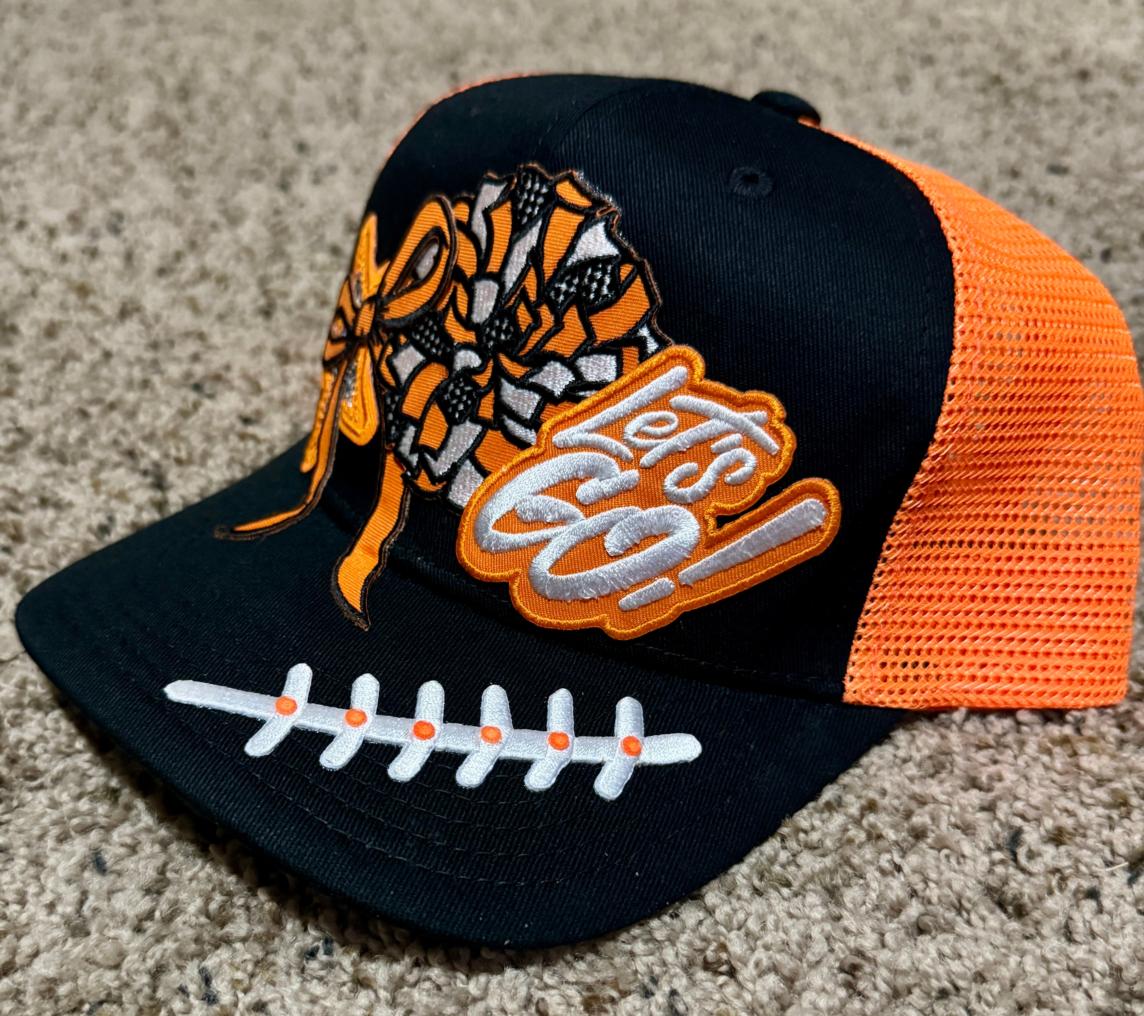 “Let’s Go!” Game Day Trucker Hat – Black & Orange Mesh, Cheer Bow & Football Patch Cap